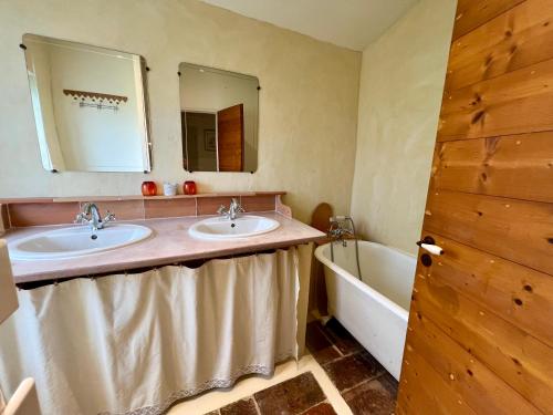 une salle de bain avec deux lavabos et une baignoire dans l'établissement Gîte la Maison du Queyran, à Villefranche-du-Queyran