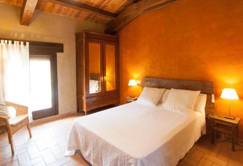 a bedroom with a white bed and a window at O Chardinet d'a Formiga in Aínsa