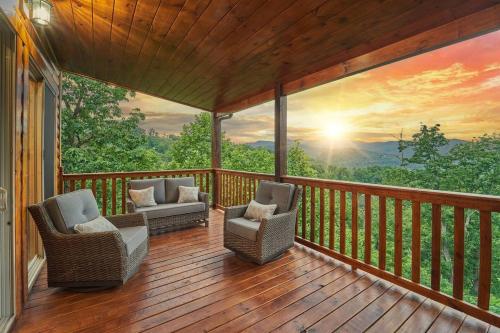 a screened in porch with two chairs and a sunset mural at Mountain View, Indoor Pool, Luxury Cabin, Bears in Gatlinburg