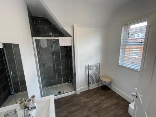 a bathroom with a walk in shower and a sink at ISUITES in Newcastle under Lyme