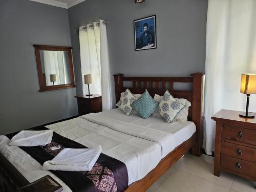 a bedroom with a large bed and a mirror at B&F Kensington Square in Siolim