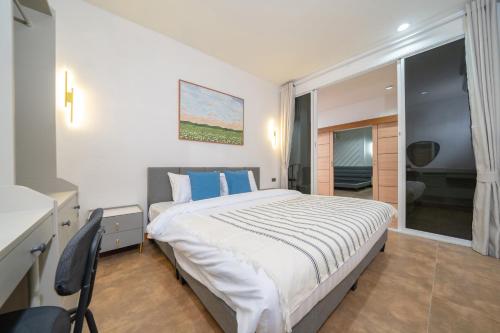 a bedroom with a large bed with blue pillows at Private patong home 4BR Jazzuci and 3 BR minimal, pick the house before book in Patong Beach