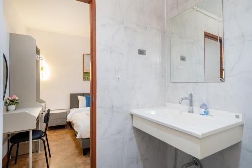 Un baño blanco con lavabo y un dormitorio. en Patong private home 4BR Jazzuci sleep 10, en Patong Beach