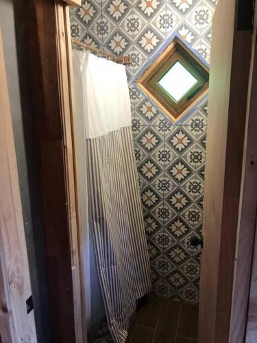 a bathroom with a shower and a tile wall at Chepu - Lodge Chimango Caracara in Chepu