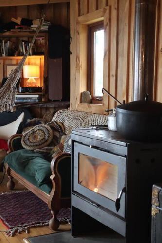 a living room with a stove with a fire at Chepu - Lodge Chimango Caracara in Chepu