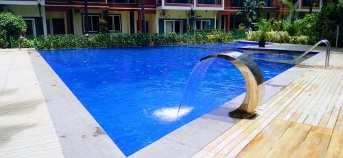 a pool with a water fountain in the middle at Couple Friendly Bath Tub Flats in Arpora