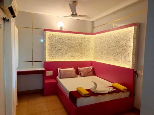 a small room with a red and white bed in a room at Couple Friendly Bath Tub Flats in Arpora