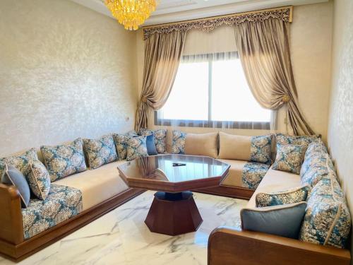 a living room with a couch and a coffee table at Rayon du soleil 7 & Restaurant in Beni Touzine