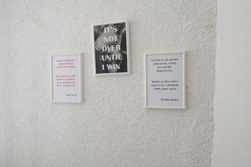 three signs hanging on a white wall withcriptions at OFOO Zagreb in Zagreb
