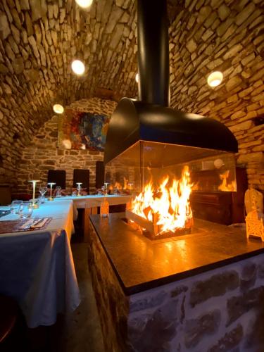 a fireplace in a restaurant with two tables and a table sidx sidx at B&B Maison des Etoiles Chambre d'hôtes Adult Only in Verrières
