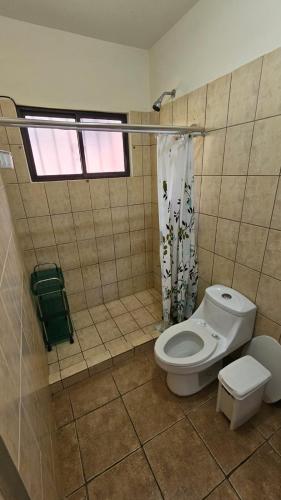 a bathroom with a white toilet and a window at Sweet Dreams #4 in Coco