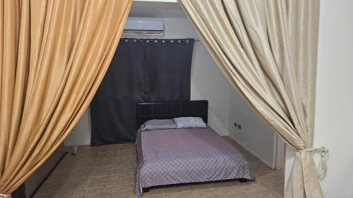 a small bed in a room with curtains at Sweet Dreams #4 in Coco