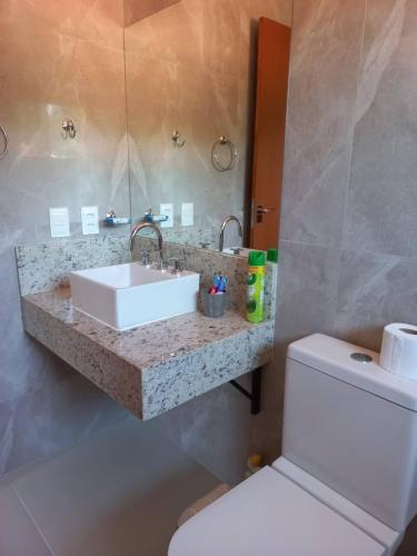 a bathroom with a sink and a toilet at Encanto da Serra Suítes Lumiar in Lumiar
