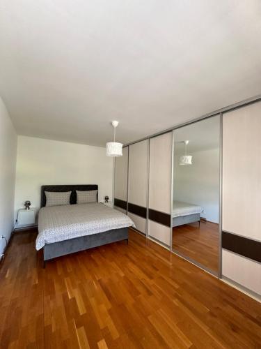 a bedroom with a bed and a wooden floor at Apartman Siesta in Kiseljak