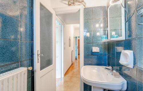 a blue tiled bathroom with a sink and a mirror at Casa La Rondine in Carro