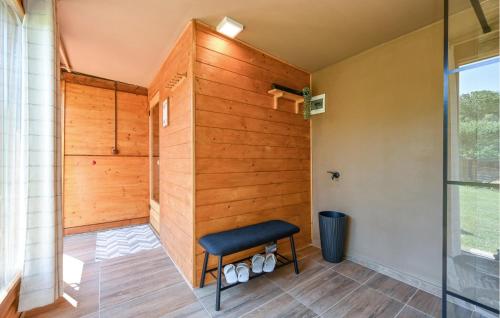 a bathroom with a wooden wall and a stool at Lovely Home In Vinogradi Ludbreski in Ludbreg