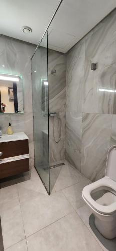 a bathroom with a shower and a toilet and a sink at Appartement luxe Taghazout bay - mer & piscine in Agadir