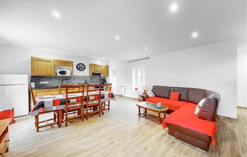 un salon avec un canapé rouge et une cuisine dans l'établissement Nice Home In Grainville-La-Teinturi, à Grainville-la-Teinturière