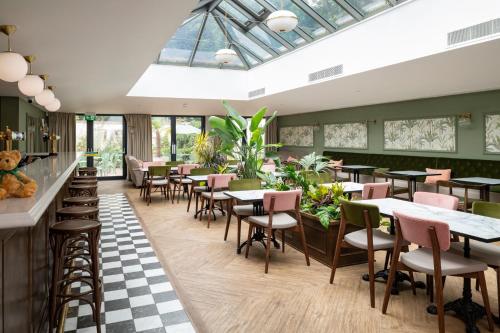 a restaurant with tables and chairs and windows at Lydiard Park Hotel in Swindon
