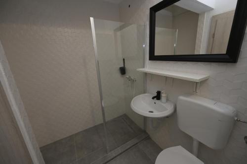 a bathroom with a toilet and a sink and a mirror at OFOO Zagreb in Zagreb