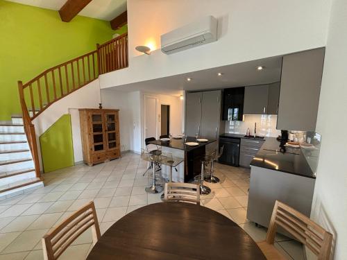 une cuisine avec une table et une cuisine avec un escalier dans l'établissement Superbe duplex tout équipé, climatisation, terrasse et barbecue, à La Seyne-sur-Mer