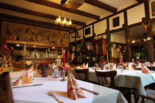 ein Restaurant mit Tischen und ein Mann im Hintergrund in der Unterkunft Landgasthof Rieger in Dangenstorf