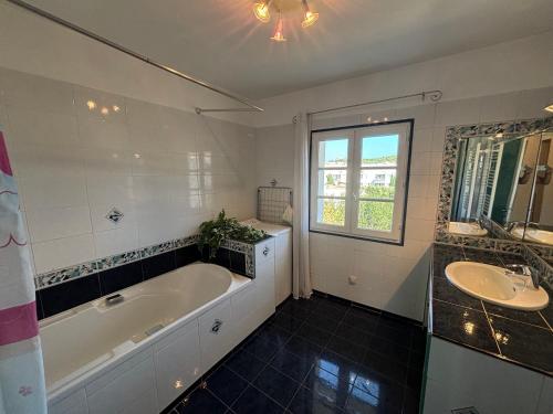 une salle de bain avec une baignoire et un lavabo dans l'établissement Superbe duplex tout équipé, climatisation, terrasse et barbecue, à La Seyne-sur-Mer