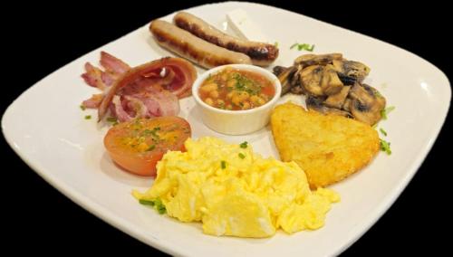 a plate of breakfast food with eggs sausage and mushrooms at The Brook Lodge in Galway