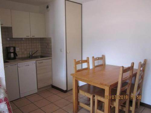 - une cuisine avec une table et des chaises en bois dans la chambre dans l'établissement Studio 4 personnes, à Briançon