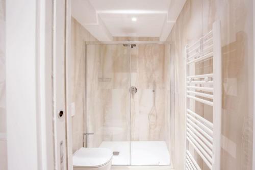 a white bathroom with a shower and a toilet at Servi Deluxe Apartament in Florence