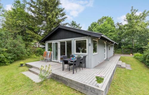 a tiny house with a deck with a table at 2 Bedroom Nice Home In Rønde in Rønde