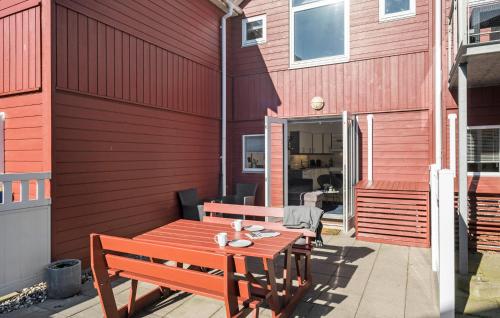 a red building with a wooden table and benches at Stunning Home In Hadsund With Wifi in Hadsund