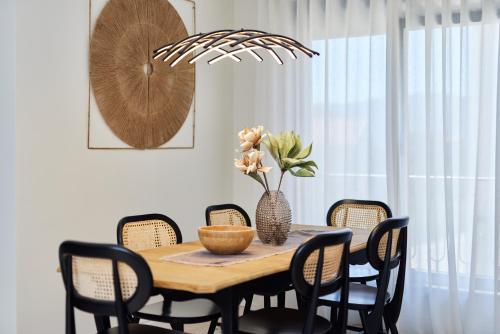 a dining room table with chairs and a vase with flowers at Dimitris Residence in Tivat
