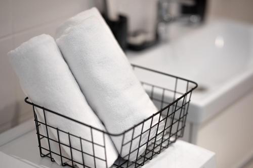 een mand met handdoeken op een wastafel bij Apartamenty Zielona in Zielona Góra