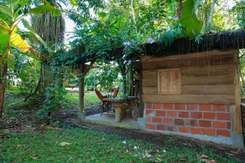 a brick building with a table and chairs in a yard at Maskani Wasi in Lago Agrio