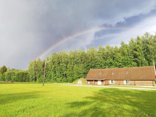 a rainbow over a house in a field at Kauksi Puhkemaja in Kauksi