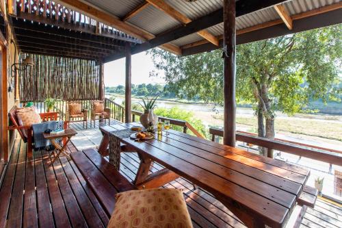 a wooden deck with a wooden table and chairs at Hennie's Rest in Malelane