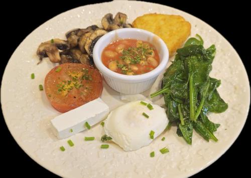 a white plate of food with mushrooms and sauce at Ardawn House in Galway
