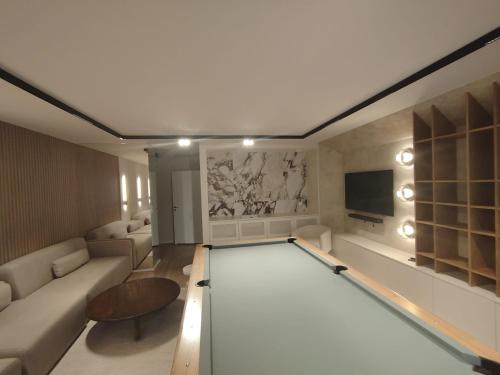a living room with a couch and a tv at Trimare Blue Apartament Sztutowo in Sztutowo