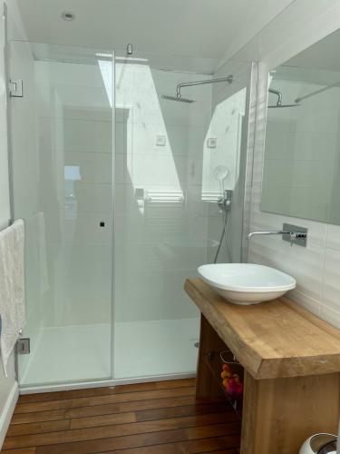 ein weißes Badezimmer mit Waschbecken und Dusche in der Unterkunft Villa 7 in Le Moutchic