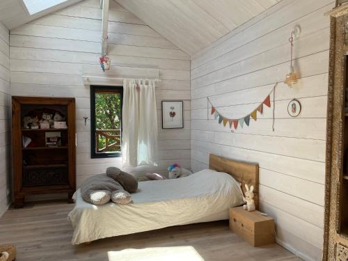 ein Schlafzimmer mit einem Bett in einem Zimmer mit Holzwänden in der Unterkunft Villa 7 in Le Moutchic