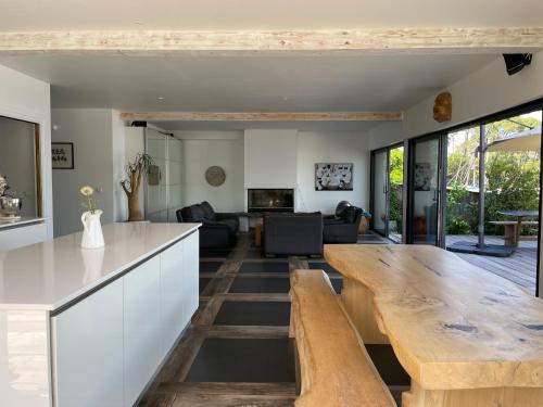 Il comprend une cuisine et un salon avec une grande table en bois. dans l'établissement Villa 7, à Le Moutchic