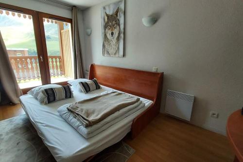 - un lit dans une chambre avec une photo de loup sur le mur dans l'établissement Studio 4 personnes La Mongie piscine salle de sport wifi, à La Mongie