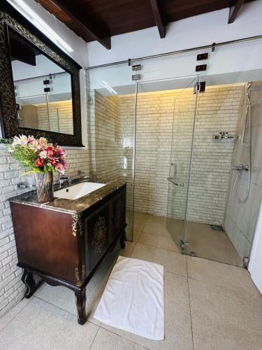 a bathroom with a sink and a shower at Pedro Barn Hotel at Little England Cottages in Nuwara Eliya
