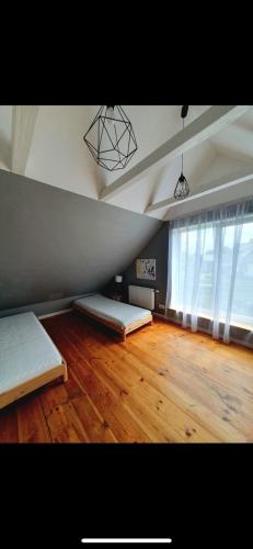 a room with two beds and a wooden floor at Divstavu maja Gulbene in Gulbene