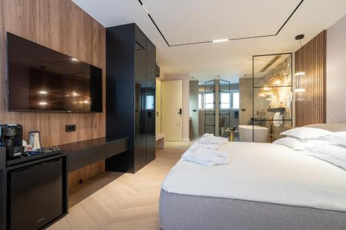 a bedroom with a large white bed and a bathroom at Luxury Rooms - FOR GIFT in Zadar