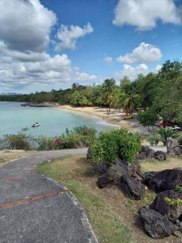 a view of a beach with a boat in the water at Studio Le Jacana dans une résidence de vacances avec piscine in Bellevue