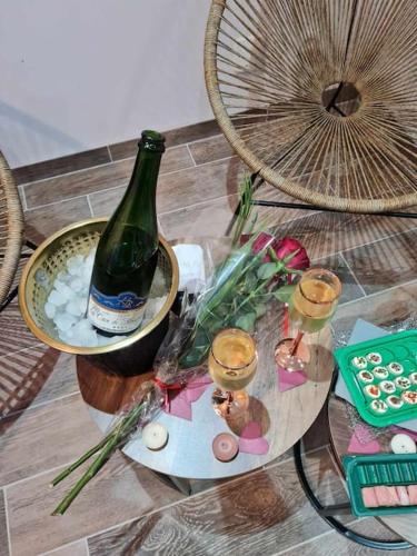 - une table en verre avec une bouteille de vin et des bougies dans l'établissement Maison cosy avec jacuzzi, à Thourotte