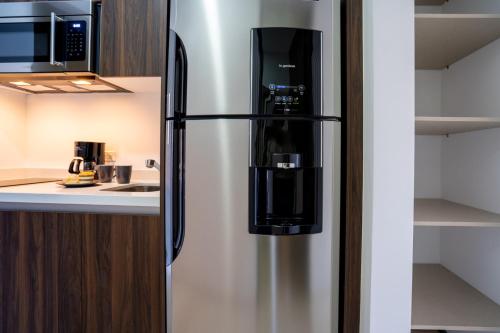 a stainless steel refrigerator in a kitchen at Modernos Estudios a pasos De La 5ta Av Pool view - By Yeah in Playa del Carmen