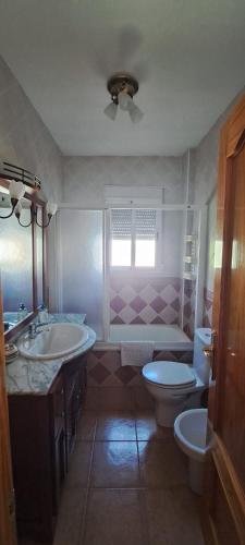 a bathroom with two sinks and a toilet and a tub at Casa Rural Fuente del Céfano in Arroyo Frio